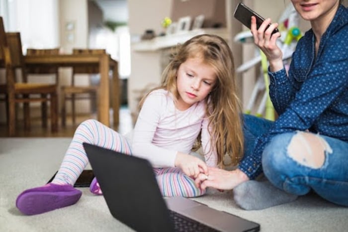 Parent guiding a child on safe internet use at home