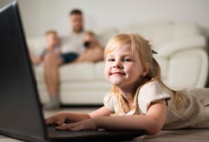 Child learning online safety skills while using a laptop at home