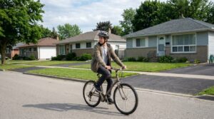 A teenage rider glancing back over one shoulder mid-ride on an empty suburban street.