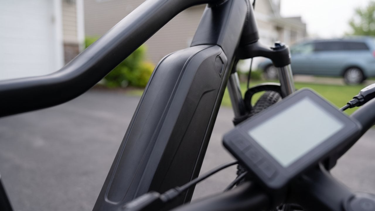 Three photographs: a small permanent label on a frame near the pedals, an owner's manual open at a specifications page, and a handlebar display showing an assist level and a speed.